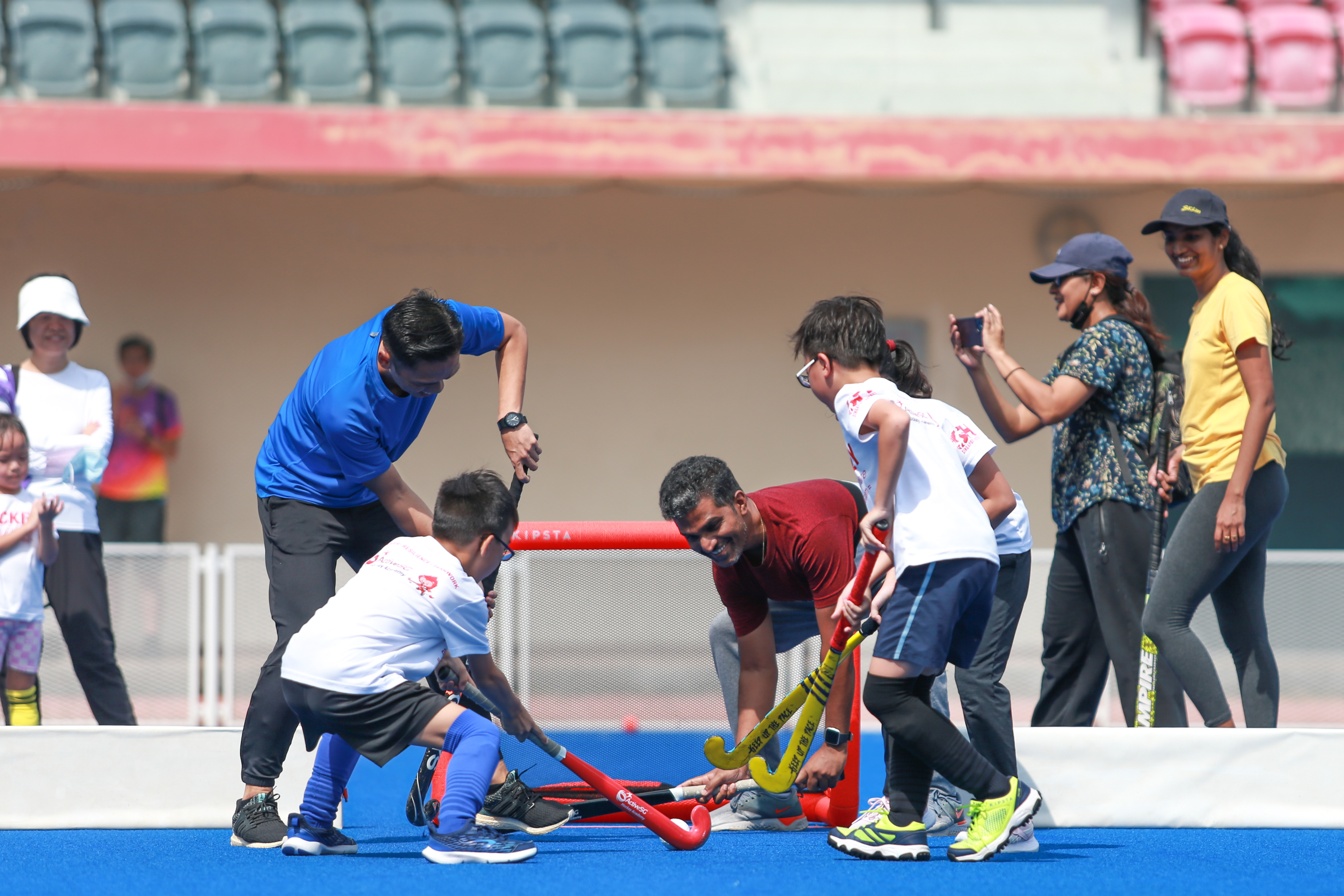 Parents and children playing a game of hockey